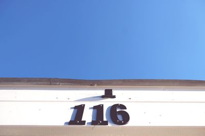 Information sign against clear blue sky