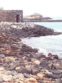 Rocks on beach against clear sky