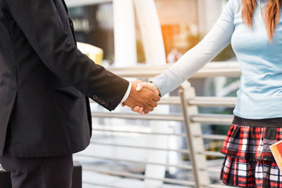 Midsection of couple holding hands