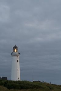 Lighthouse by sea against sky