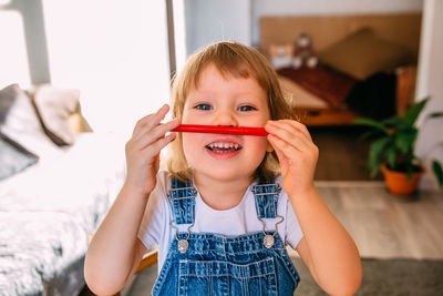 Small child at home at the children's table draws with felt-tip pens.