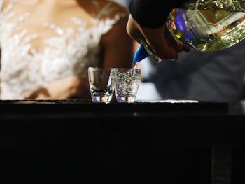 Midsection of man holding wine glass on table