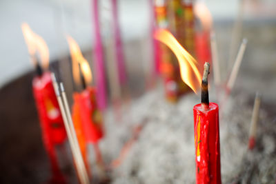 Close-up of red burning candles in temple