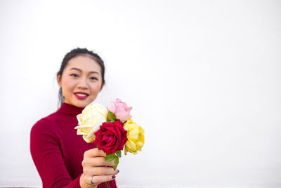 Portrait of a smiling young woman against white background