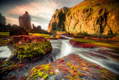 Scenic view of waterfall against sky