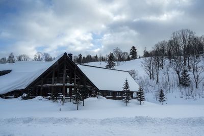 Built structure on snow covered field against sky