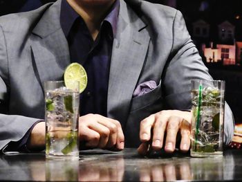 Close-up of man drinking glasses on table