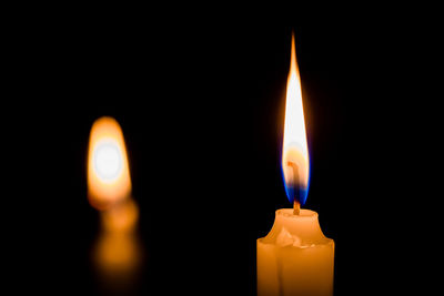 Close-up of lit candle in darkroom