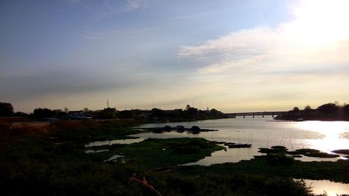 Scenic view of river against cloudy sky