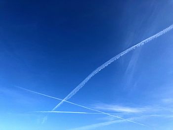 Low angle view of vapor trail in blue sky