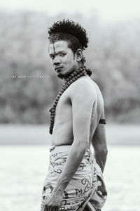 Close-up of shirtless man in water against sky