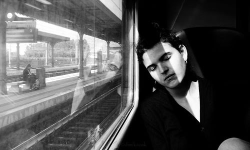 Young woman sitting on train window