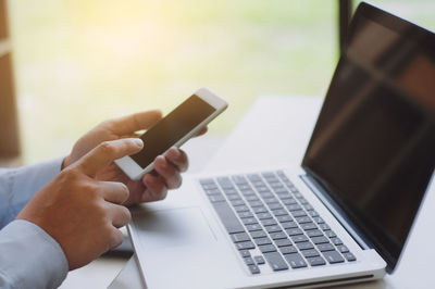 Midsection of man using mobile phone