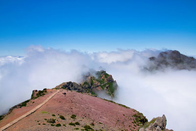 Scenic view of mountain against blue sky