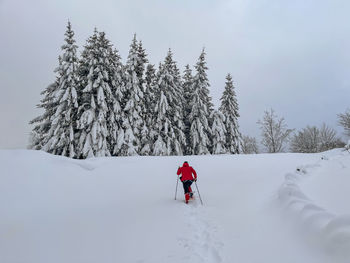 Full length rear view of woman skiing on snow covered land during winter