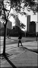 Man walking on sidewalk by street in city