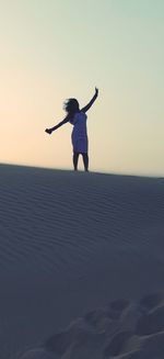 Silhouette woman on sands of desert