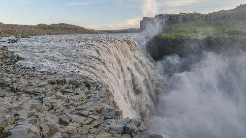 Scenic view of waterfall against sky