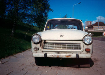 Vintage car on street against trees