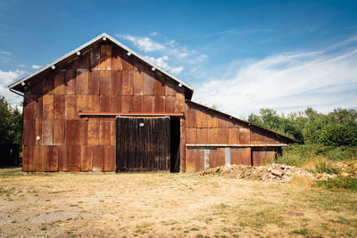 Abandoned building on field against sky