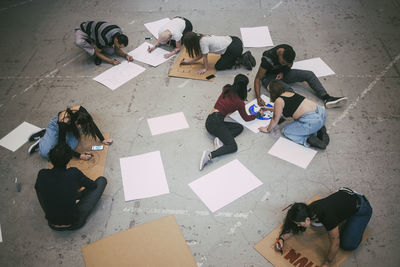 Male and female protestors preparing signboards in building