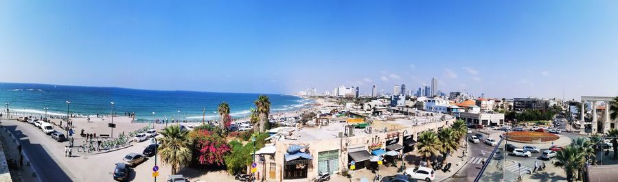 High angle view of buildings by sea against blue sky