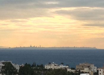 View of cityscape against cloudy sky