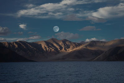 Scenic view of sea and mountains against sky