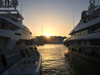 Boats sailing in sea against sky during sunset