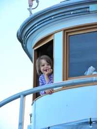 Low angle view of girl looking through window in lighthouse