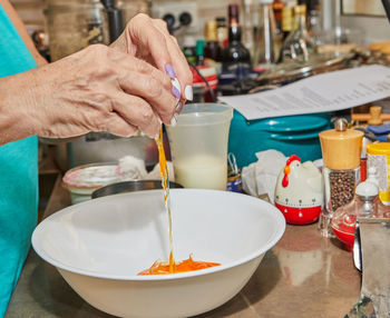 Cropped hands of man preparing food in kitchen