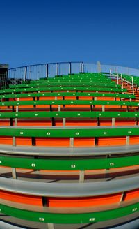 Multi colored chairs against clear blue sky