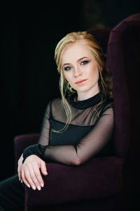 Portrait of young woman sitting on seat
