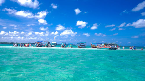 Boats in sea against blue sky