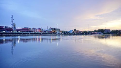 Reflection of buildings in river against sky