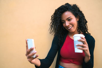 Portrait of smiling young woman using mobile phone