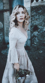 Portrait of woman standing against wall