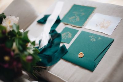 Close-up of green envelope on bed