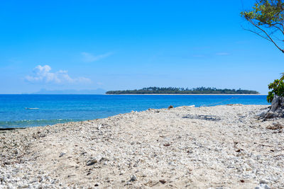 Scenic view of beach against blue sky