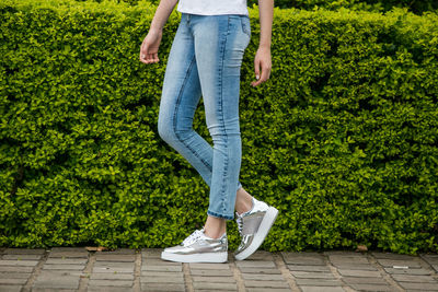 Low section of woman wearing shoes while standing outdoors