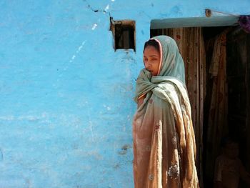 Close-up of woman standing against wall