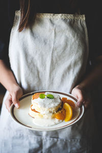 Midsection of woman holding breakfast in plate