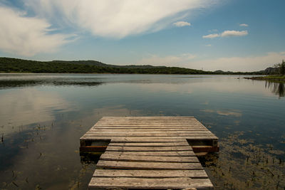 Pier over lake against sky