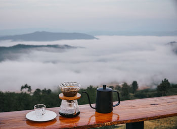 Coffee cup on table against sky