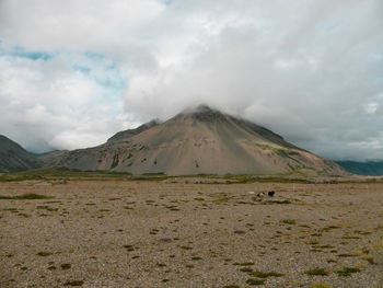 View of volcanic landscape against cloudy sky