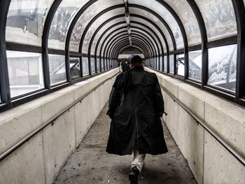 Rear view of woman standing in tunnel