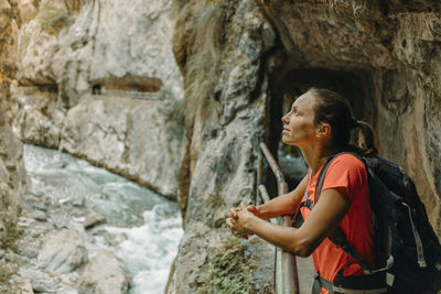 Side view of woman looking away rock