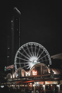 Low angle view of illuminated ferris wheel at night