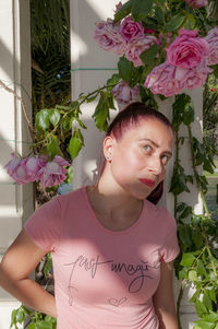 Portrait of young woman with pink flowers