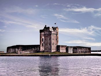 Castle by building against sky